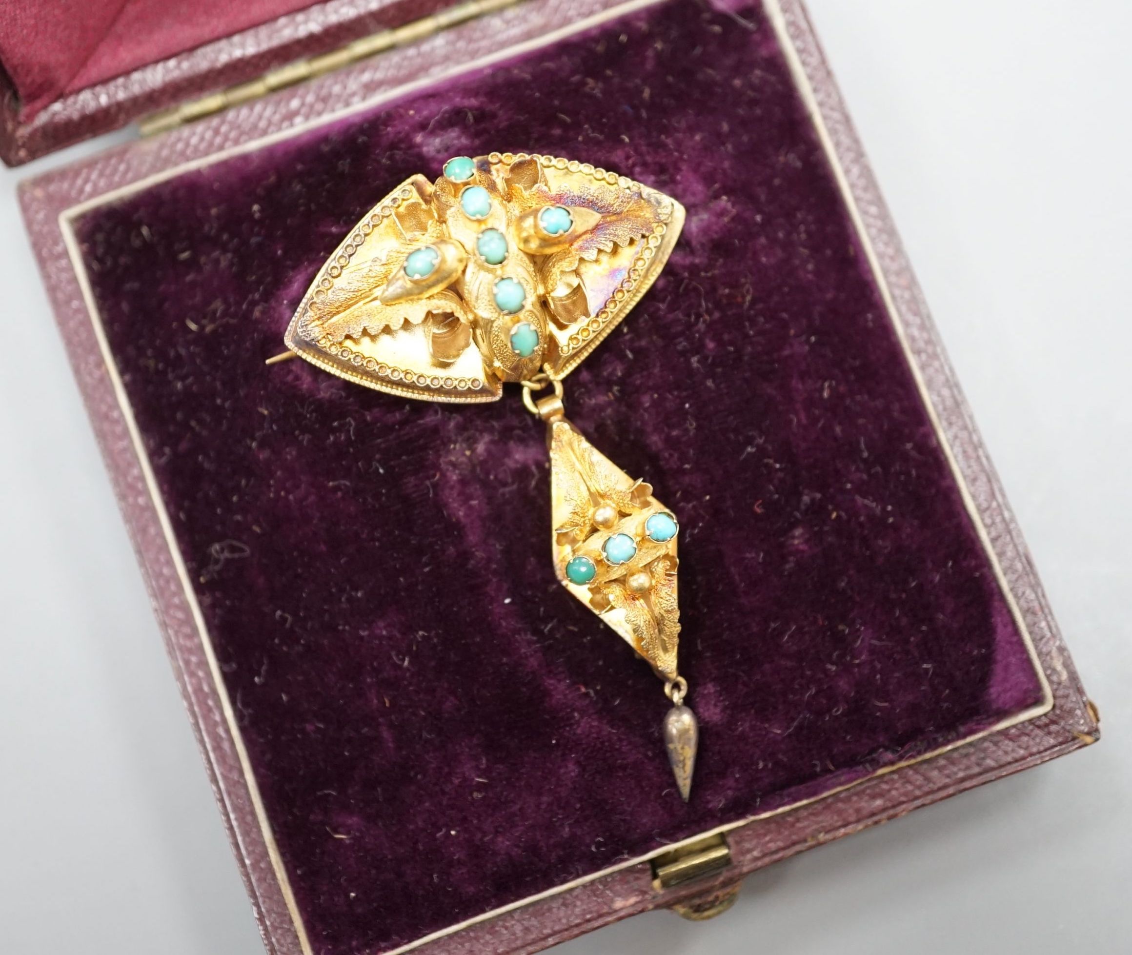 A Victorian yellow metal and cabochon turquoise set drop brooch, in fitted leather box, 55mm, gross 4.9 grams.